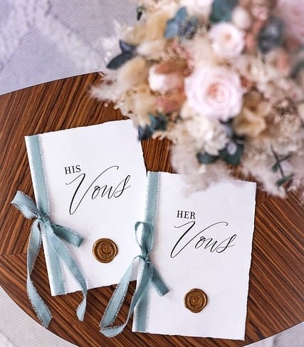 two cards on a table labelled his vows and her vows